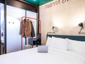 une chambre d'hôtel avec un lit et un placard dans l'établissement ibis Styles Bern City, à Berne