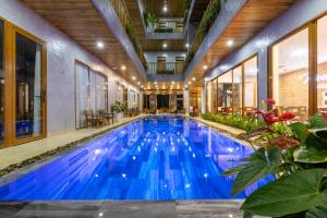 una piscina cubierta con agua azul en un edificio en Moon Sun Boutique Villa Hotel, en Hue