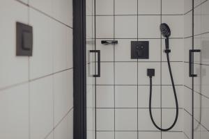 een douche met een douchekop in de badkamer bij Cabane Urbaine 1 - centre in Namen