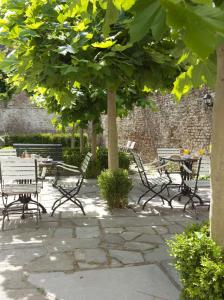 un groupe de bancs et de tables de parc sous les arbres dans l'établissement Boutique hotel Sint Jacob, à Maastricht