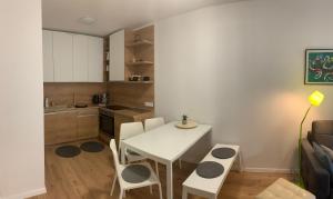 a small kitchen with a white table and chairs at Apartmán Jeleň Chopok Juh-Trangoška in Tale