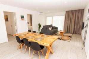 sala de estar con mesa de madera y sillas en Ericeira Surf Apartments, en Ericeira