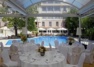 a marquee with tables and chairs in front of a pool at Theoxenia Palace in Athens