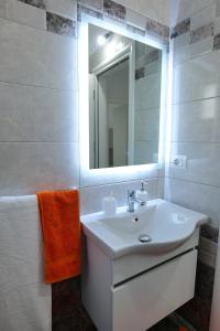 y baño con lavabo blanco y espejo. en Davide Rooms, en Sarandë