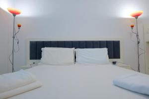 1 dormitorio con 1 cama blanca grande y 2 lámparas en Davide Rooms, en Sarandë