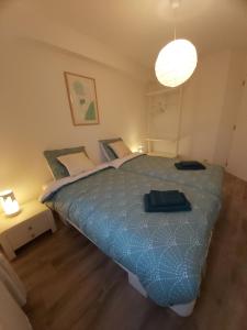 Schlafzimmer mit einem großen Bett mit blauer Decke in der Unterkunft Sea & the City in Blankenberge