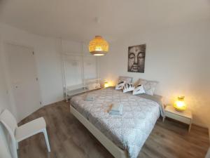 ein Schlafzimmer mit einem großen Bett mit zwei Leuchten in der Unterkunft Sea & the City in Blankenberge