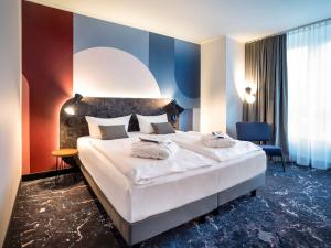 ein Schlafzimmer mit einem großen weißen Bett und einer blauen Wand in der Unterkunft Mercure Mainz City Center in Mainz