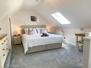 - une chambre avec un lit et une lucarne dans l'établissement Modern 4-bed Cottage Llanwrst Town Centre & Parking - Snowdonia! near Betws-y-Coed, à Llanrwst