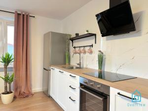 cocina con fregadero y nevera en Hel Apartment, en Borkowo