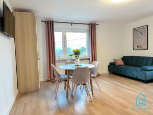 sala de estar con mesa, sillas y sofá en Hel Apartment, en Borkowo