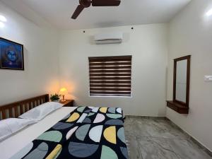 阿勒皮Solomon Apartments,Alappuzha beach.的一间卧室配有一张床和吊扇