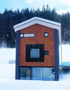 um edifício com uma janela na neve em Chalet Malino - Apartments em Ružomberok