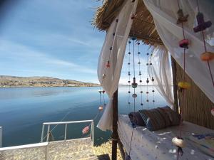 - un bateau avec un lit et une vue sur l'eau dans l'établissement Uros Lake Titicaca Lodge, à Puno