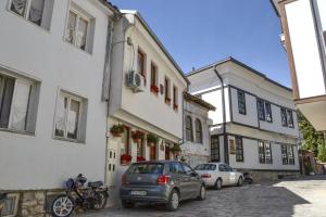 une rue avec deux voitures garées devant les bâtiments dans l'établissement Casa Germanoff, à Ohrid