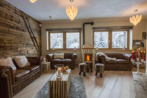 a living room with leather furniture and a fireplace at Residence Aspen in Arabba