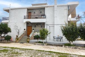 Casa blanca grande con escaleras y mesa en Paradeisos, en Kardhamili