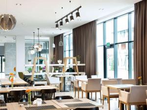 ein Restaurant mit Tischen und Stühlen und großen Fenstern in der Unterkunft ibis Styles Siedlce in Siedlce