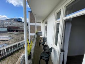 d'un balcon avec deux chaises et une fenêtre. dans l'établissement Topsleep Apartments 24-2, à Arnhem