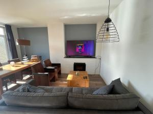 - un salon avec un canapé et une télévision murale dans l'établissement Topsleep Apartments 24-2, à Arnhem