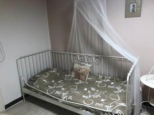 a bed with a canopy with a teddy bear on it at Les Lumerettes - Dohan in Bouillon