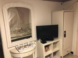 a bedroom with a mirror and a tv and a bed at Les Lumerettes - Dohan in Bouillon