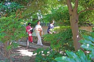 横滨日本庭園古民家　飯田屋　Traditional experience iidayajapan的一群站在公园里的三人