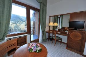 una camera d'albergo con tavolo e ampia finestra di Grand Hotel Cesare Augusto a Sorrento