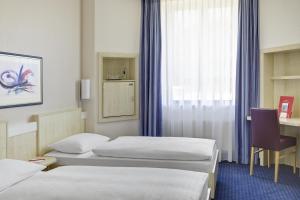 A bed or beds in a room at IntercityHotel Kassel