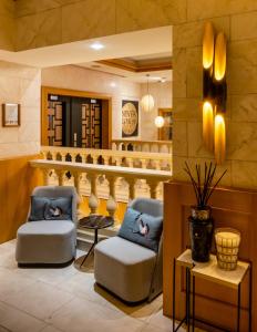 a lobby with two chairs and a table at Hotel Le Châtelain in Brussels