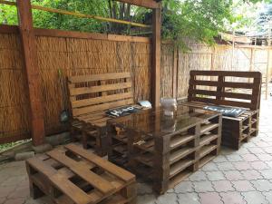 a patio with two benches and a table and chairs at Мандри Хостел in Uzhhorod