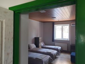 a room with three beds and a window at Мандри Хостел in Uzhhorod