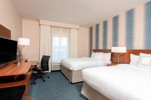 Fairfield Inn & Suites by Marriott Indianapolis Carmel في كارميل: غرفة فندقية بسريرين ومكتب وتلفزيون