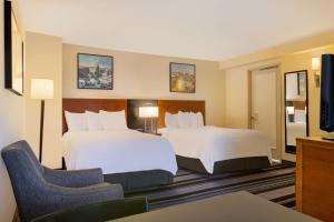 una camera d'albergo con due letti e una sedia di Residence Inn by Marriott New York Manhattan/Times Square a New York