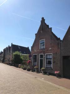 een bakstenen gebouw op een geplaveide straat bij De Scheve Deur in Vollenhove