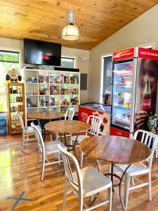 un restaurant avec des tables, des chaises et une machine à soda dans l'établissement BIG4 Port Willunga Tourist Park, à Aldinga