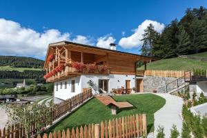 a house on a hill with a wooden fence at Apartment Mittermanting in Villnoss