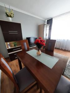 uma mesa de jantar com um vaso de flores em Słoneczny Apartament w Busku-Zdroju em Busko-Zdrój