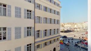 um edifício alto ao lado de uma rua com carros em Le Pytheas Vieux Port Marseille em Marselha