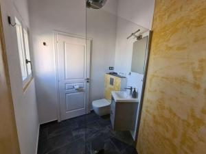 bagno con servizi igienici bianchi e lavandino di Gythio townhouse a Gythio