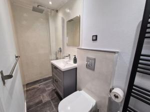 bagno con servizi igienici bianchi e lavandino di Gythio townhouse a Gythio