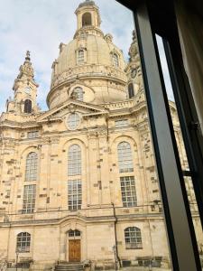 ein Gebäude mit einem Uhrturm darüber in der Unterkunft Aparthotel Altes Dresden in Dresden