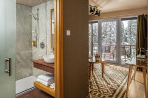 bagno con vasca, doccia e lavandino di Ana Hotels Sport Poiana Brasov a Poiana Brasov