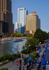 een groep mensen die op een stoep naast een rivier lopen bij Loews Chicago Hotel in Chicago