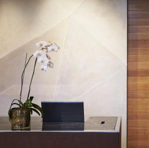 - un bureau avec un ordinateur portable et une fleur dans un vase dans l'établissement Loews Chicago O'Hare Hotel, à Rosemont