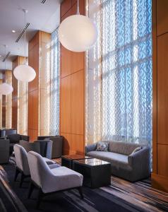 - un hall avec un canapé, des chaises et une fenêtre dans l'établissement Loews Chicago O'Hare Hotel, à Rosemont