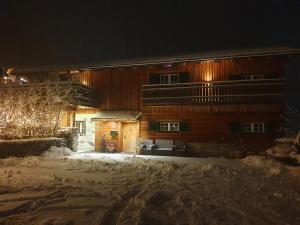 ein Holzgebäude im Schnee in der Nacht in der Unterkunft Gut Unterbrunn in Radstadt