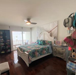 a bedroom with a bed and a ceiling fan at Bay Beach Bungalow in San Diego