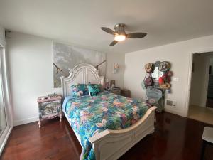 a bedroom with a bed and a ceiling fan at Bay Beach Bungalow in San Diego