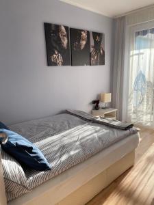 um quarto com uma cama com três fotografias na parede em Belu Apartman em Balatonlelle